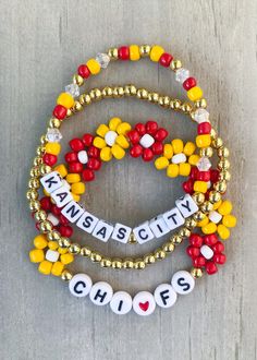 Kansas City Bracelets ❤️💛❤️💛 Are you ready for some football?? 🏈 🏈 Get game day ready with this cute football stack. Sold individually or as a set. *If you would like something custom or different wording, please put in Personalization section* CARING TIPS FOR YOUR JEWELRY ⭐️Treat and store with care. ⭐️ For longevity, avoid exposing your jewelry to water. ⭐️ Avoid having direct contact with lotions, perfumes, sanitizers as these chemicals may cause discoloration of your jewelry. Kansas City Chiefs Jewelry, Inspired Bracelets, Football Bracelet, Kansas City Football, Sports Jewelry, Beads Bracelet Design