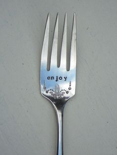 a close up of a fork with the word enjoy written on it's side