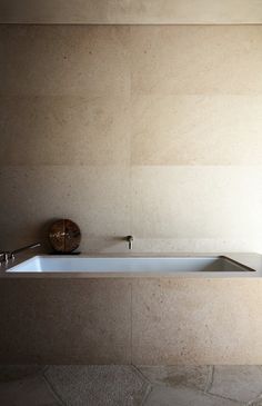 a white bath tub sitting on top of a stone floor