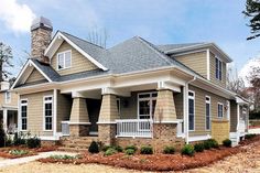 a small house with stone and shingles on the front porch, covered in white trim