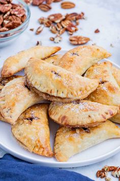 pecan pies on a white plate next to nuts