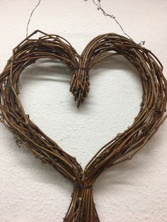 a heart made out of branches hanging on the wall