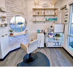 a salon room with a mirror, sink and hair dryer on the floor in front of a window