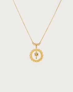 a gold necklace with the letter s on it and a small initial in the middle