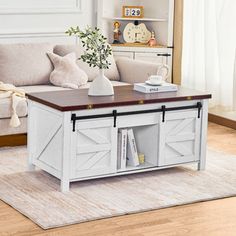 a living room with a couch, coffee table and bookshelf on the floor