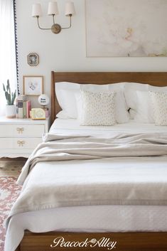 a bed with white sheets and pillows in a bedroom