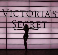 a woman standing in front of a sign that says victoria's secret