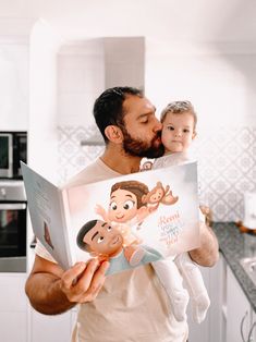 a man holding a baby and reading a book