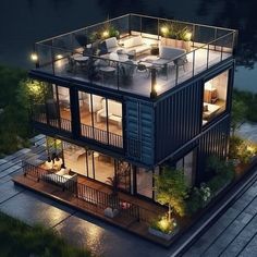 an aerial view of a shipping container home at night with lights on the balcony and deck