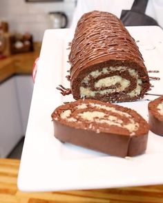 there is a chocolate roll on the plate with two slices cut out and ready to be eaten