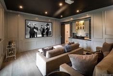 a living room filled with furniture and a flat screen tv mounted to the side of a wall