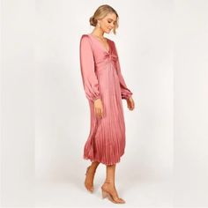 Petal & Pup Long Sleeve Satin Pleated Pink Midi Be The Centre Of Attention In This Cocktail-Ready Midi Dress! This Showstopper Features A V Neckline And Long Sleeves With Elasticised Cuffs For A Feminine Yet Flattering Silhouette. A Back Neck Opening With Button Close And Front Twist Knot On Bust Add The Perfect Finishing Touches. Midi Length V Neckline Long Sleeves With Elasticised Cuff Back Neck Opening With Button Close Front Twist Knot On Bust Back Invisible Zip Fine Pleat A-Line Skirt Desig V-neck Pleated Dress For Fall Parties, Feminine Pleated Maxi Dress For Brunch, Pink Pleated Midi Dress For Night Out, Fall Pink Pleated Dress, Pink Pleated Dress For Fall, Pink V-neck Pleated Dress For Party, Feminine Pleated Midi Dress For Party, Pink Long Sleeve Dressy Midi Dress, Feminine Flowy Midi Dress For Night Out