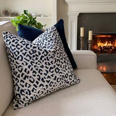 a living room with a couch, fireplace and two pillows on the back of it