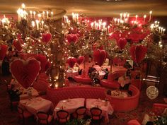 a room filled with lots of tables and chairs covered in valentine's day decorations