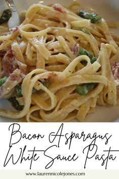 bacon and asparagus white sauce pasta on a plate with a spoon in it