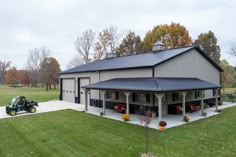 a tractor is parked in front of a large house with a metal roof and two car garages