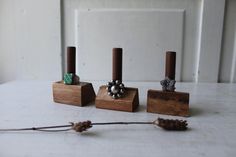 three small wooden blocks with beads on them