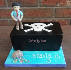 a birthday cake with a pirate theme on the front and sides, including a skull and crossbones