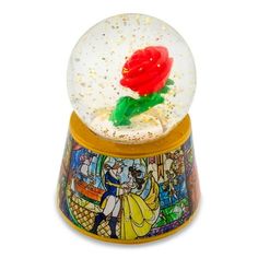 the snow globe has a red rose in it