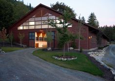 a large red building with lots of windows on it's sides and trees in the front