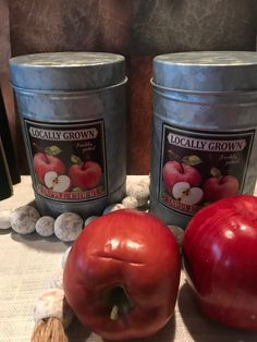 two red apples sitting on top of a table next to some nuts and an apple