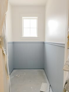 an empty bathroom with white walls and blue trim on the walls, is shown in this image