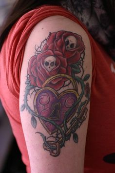 a woman with a skull and rose tattoo on her arm holding a heart shaped key