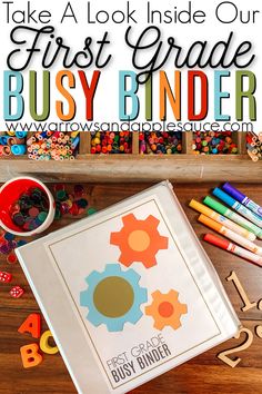 the first grade busy binder is surrounded by crayons and colored pencils