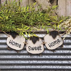 three tags with the words home, sweet home and heart hanging on a metal wall