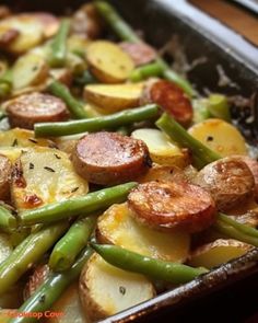 a pan filled with potatoes, green beans and sausage