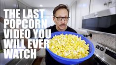 a man holding a bowl of popcorn in his kitchen with the words, the last popcorn video you will ever watch