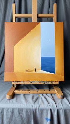 an easel sitting on top of a table with a painting in front of it