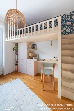 a room with stairs and a desk in the corner, next to a staircase that leads up to a loft bed