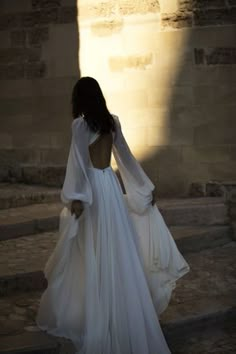 the back of a woman's dress as she walks up some steps