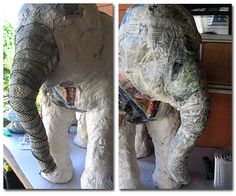 an elephant made out of newspaper sitting on top of a counter next to a window