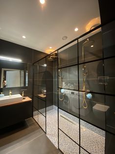 a modern bathroom with glass walls and gold fixtures