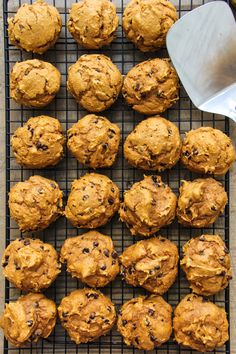 freshly baked muffins on a cooling rack with a spatula next to them