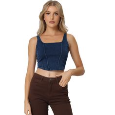 a woman wearing brown pants and a denim crop top