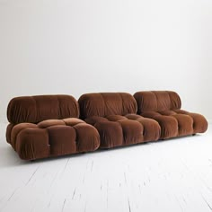 a brown couch sitting on top of a white floor