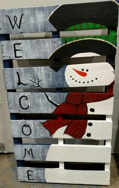 a wooden pallet with a snowman painted on it and the words welcome home