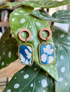 Introducing our exquisite handmade earrings, a perfect blend of creativity and nature-inspired design. Each pair is meticulously crafted with a unique cyanotype technique, showcasing the beauty of natural elements. These earrings feature unique hand-printed cyanotypes encased in resin and complemented with wood fixtures. Bohemian Pressed Flowers Drop Earrings, Nature-inspired Blue Dangle Earrings, Handmade Nature-inspired Flower Earrings, Blue Nature-inspired Drop Earrings, Nature-inspired Dangle Flower Earrings, Nature-inspired Dangle Earrings, Turquoise Nature-inspired Drop Earrings, Handmade Botanical Drop Earrings, Unique Pressed Flowers Earrings