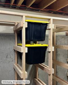 two buckets are hanging on the side of a ladder in a room that is being constructed