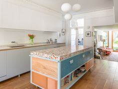 a kitchen with an island in the middle and lots of cupboards on both sides