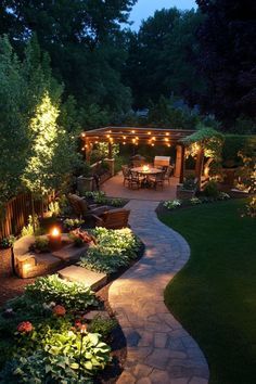 an outdoor patio with lights on the walkway and landscaping lighting up the area around it