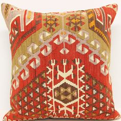 a red and yellow pillow with an intricate design on it's side, against a white background