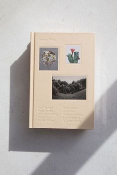 a book with pictures on it sitting on top of a white table next to a wall