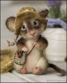 a small mouse with a hat on it's head and holding a piece of cloth