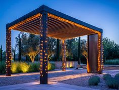 an outdoor gazebo with lights on the sides and trees in the background at night