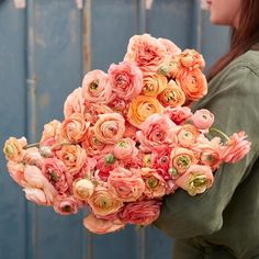 a woman holding a bouquet of pink flowers