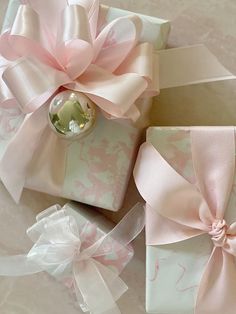 three wrapped presents with pink bows on them